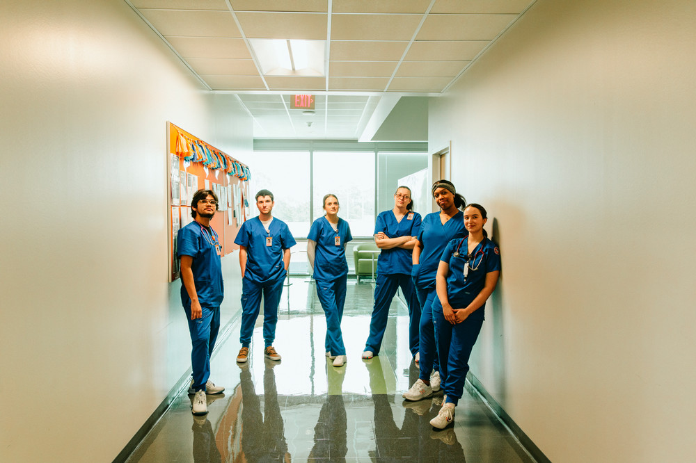 Five people in scrubs in a hallway